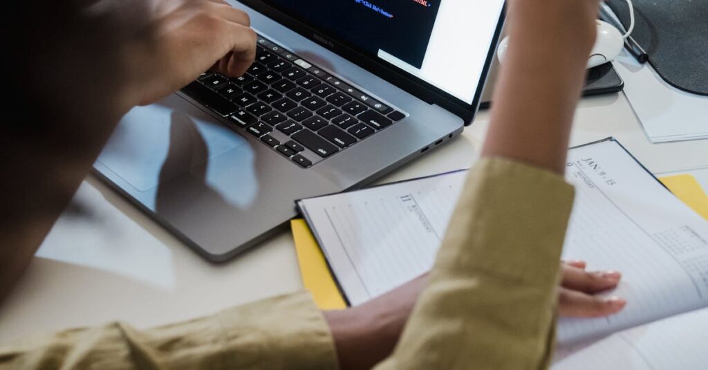 Two individuals discussing code on a laptop, focusing on web development.