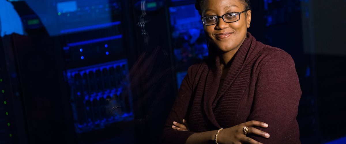 Confident woman in data center, showcasing tech expertise.